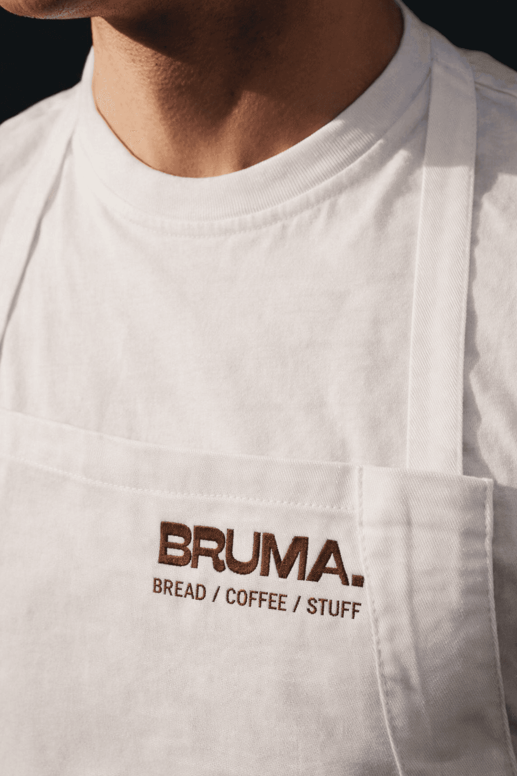BRUMA branding embroidered on a white apron.