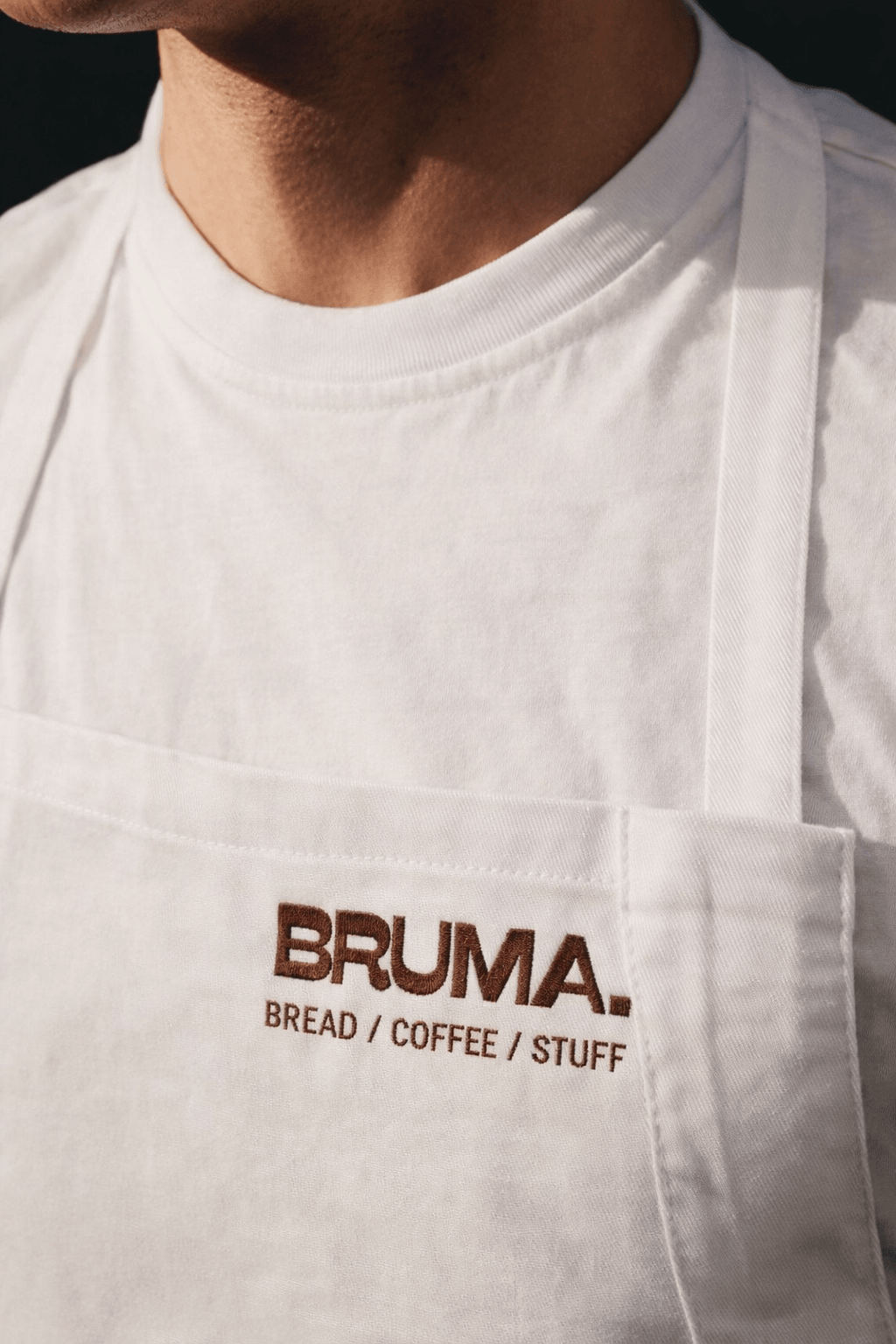 BRUMA branding embroidered on a white apron.