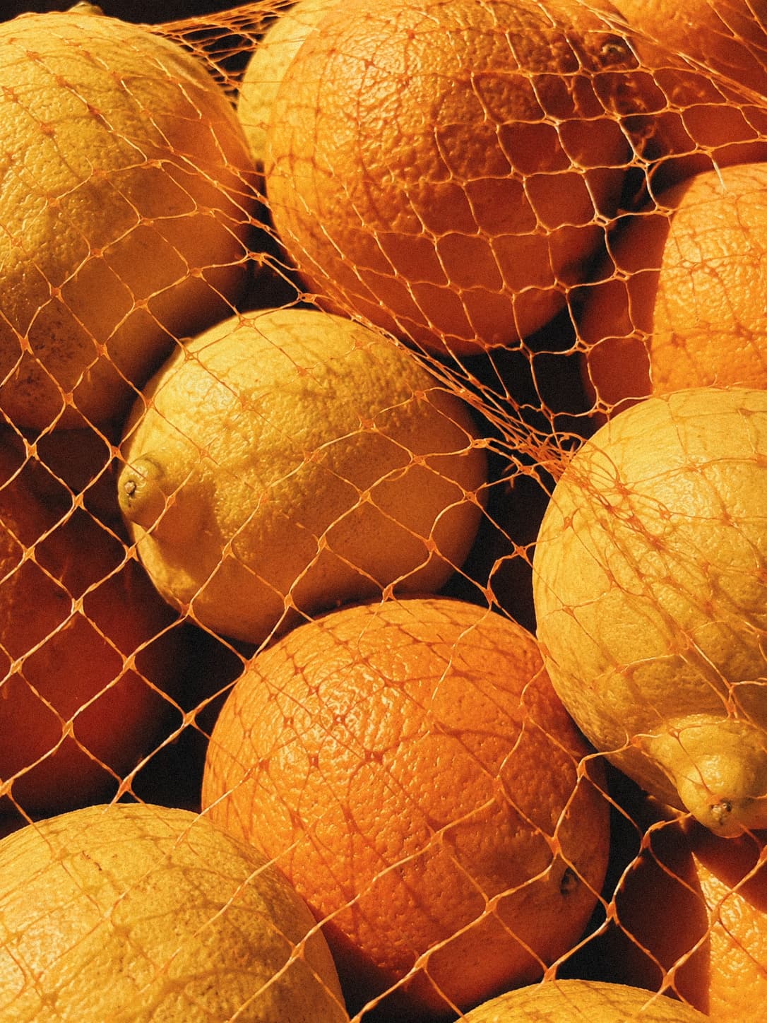 Citrus fruit gathered in a mesh bag.