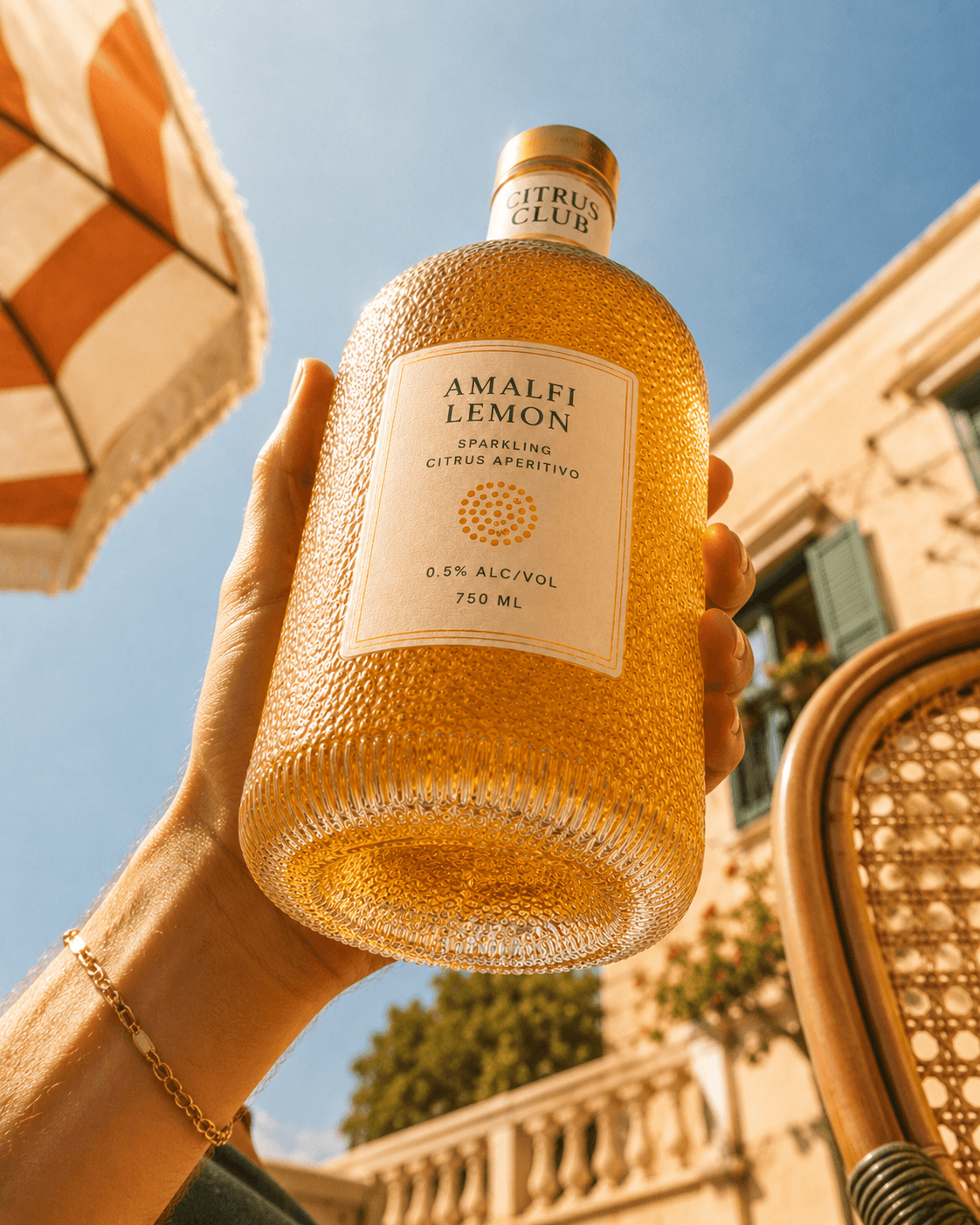 Amalfi Lemon bottle lifted into a bright Mediterranean sky.